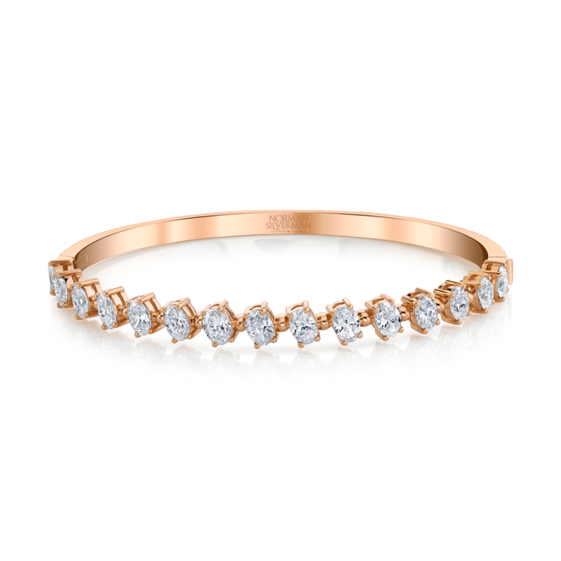 Oval-cut Diamonds set in 4-prong pink gold bangle bracelet.